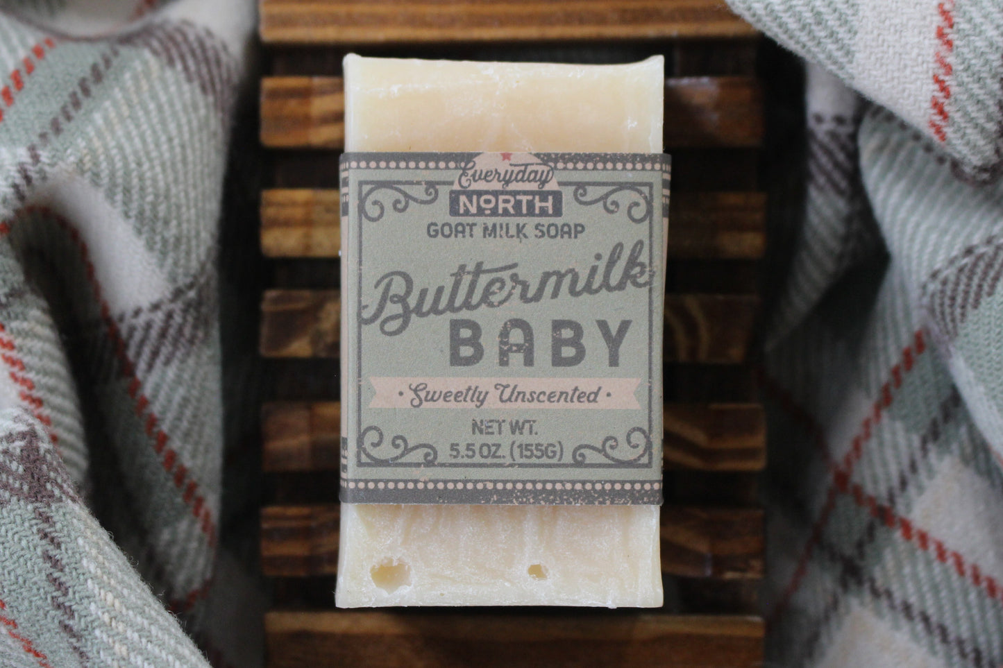 Undyed Soap Bar on Soap Dish. Wrapped in Kraft Label. Everyday North Goat Milk Soap. Buttermilk Baby. Sweetly Unscented. 5.5 oz. 155 grams. Surrounded by decor.