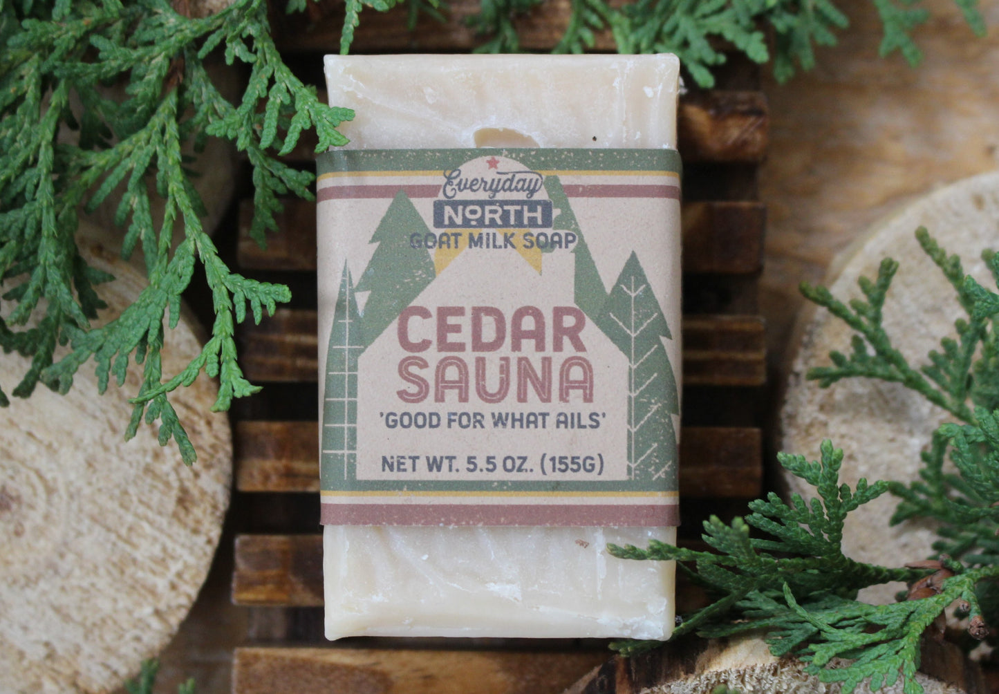 Undyed Soap Bar on Soap Dish. Wrapped in Kraft Label. Everyday North Goat Milk Soap. Cedar Sauna. Good For What Ails. 5.5 oz. 155 grams. Surrounded by decor.