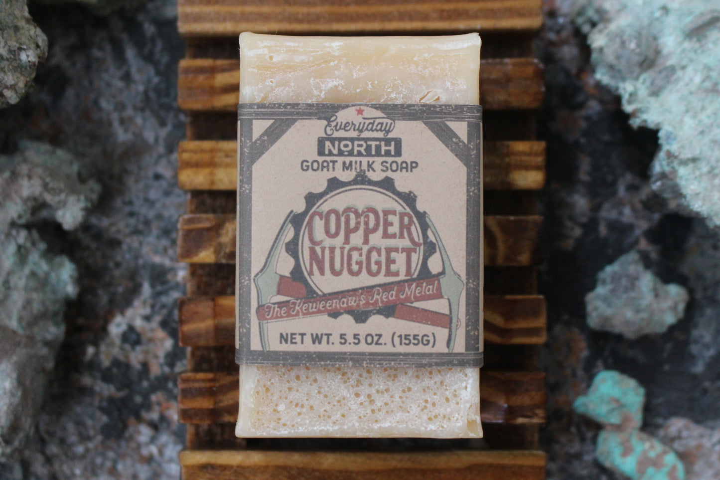Undyed Soap Bar on Soap Dish. Wrapped in Kraft Label. Everyday North Goat Milk Soap. Copper Nugget. The Keweenaw's Red Metal. 5.5 oz. 155 grams. Surrounded by decor.