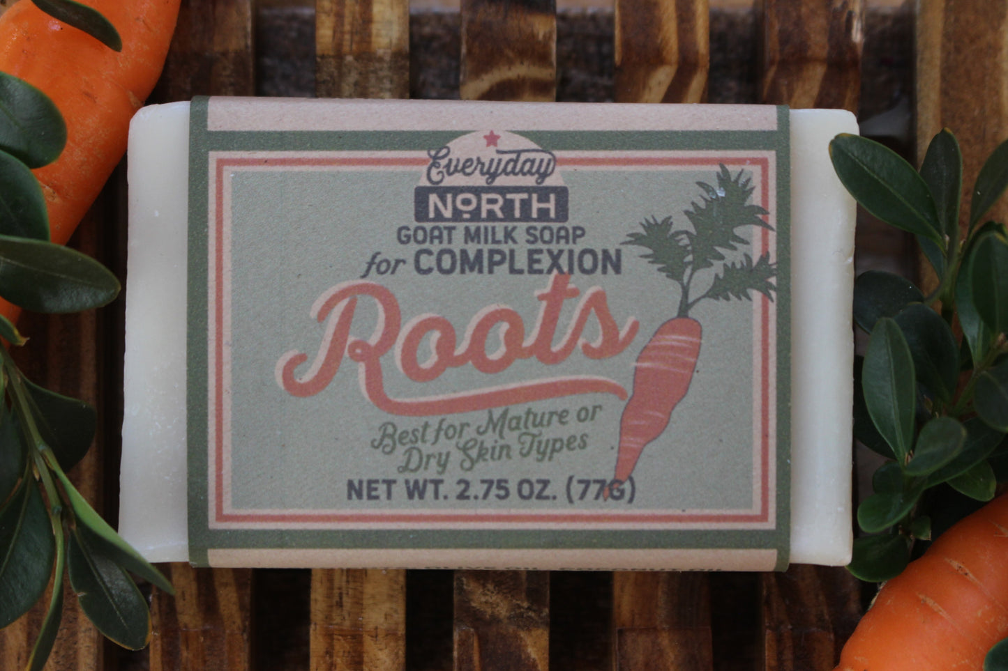 Undyed Soap Bar on Soap Dish. Wrapped in Kraft Label. Everyday North Goat Milk Soap for Complexion. Roots. Best For Mature or Dry Skin Types. 2.75 oz. 77 grams. Surrounded by decor.