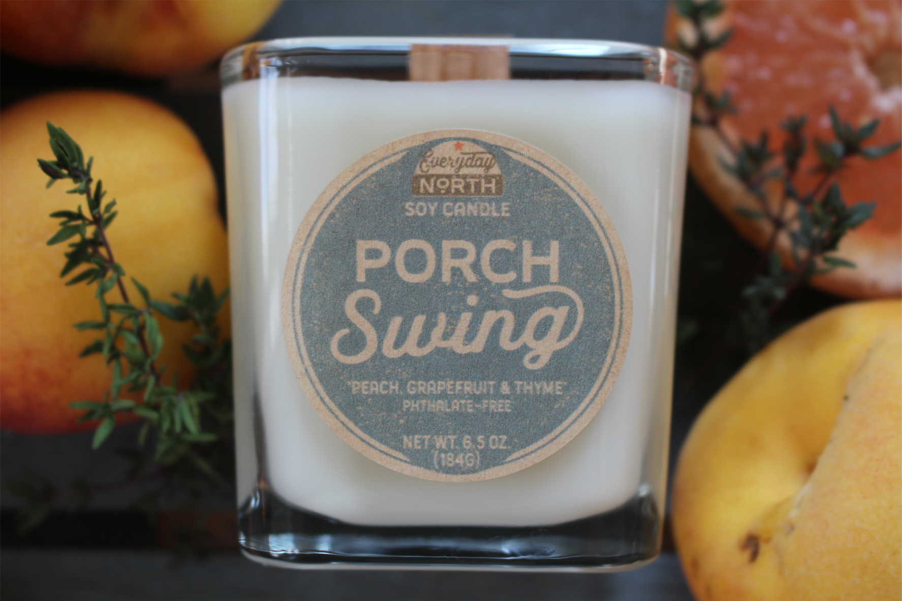 Everyday North Wood Wick Soy Candle. Porch Swing. Peach, Grapefruit and Thyme. Phthalate Free. 6.5 oz. 184 grams. Decor Surrounding Undyed Soy Wax Candle in Cube Glass Jar.