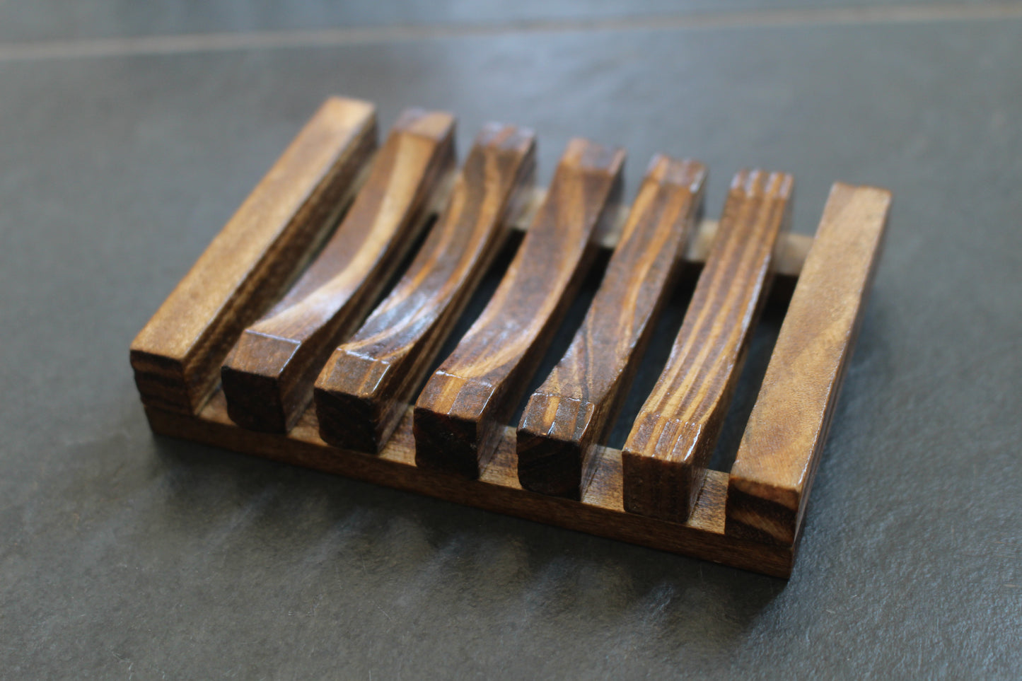 Wood soap dish, seven slats, center five concave, dark stained.