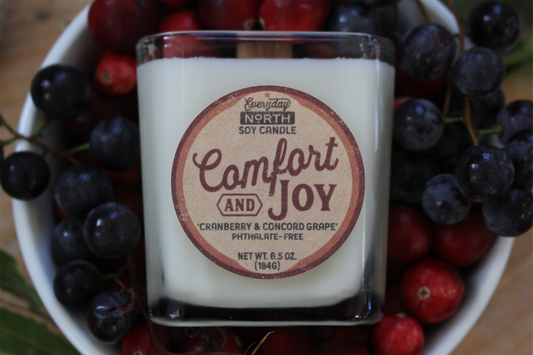 Everyday North Wood Wick Soy Candle. Comfort and Joy. Cranberry and Concord Grape. Phthalate Free. 6.5 oz. 184 grams. Decor Surrounding Undyed Soy Wax Candle in Cube Glass Jar.