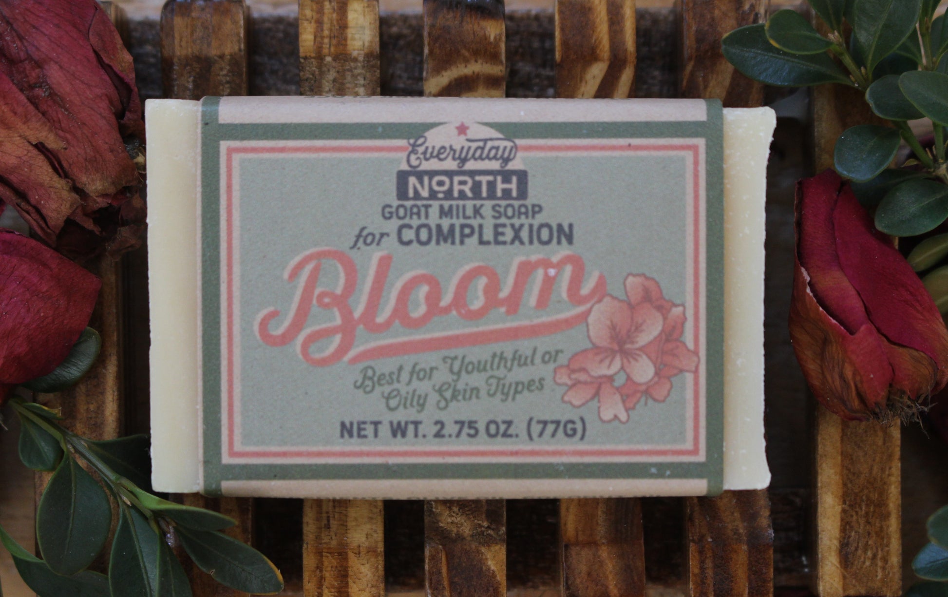 Undyed Soap Bar on Soap Dish. Wrapped in Kraft Label. Everyday North Goat Milk Soap for Complexion. Bloom. Best For Youthful or Oily Skin Types. 2.75 oz. 77 grams. Surrounded by decor. 