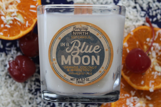 Everyday North Wood Wick Soy Candle. In a Blue Moon. Orange, Coconut and Maraschino. Phthalate Free. 6.5 oz. 184 grams. Decor Surrounding Undyed Soy Wax Candle in Cube Glass Jar.