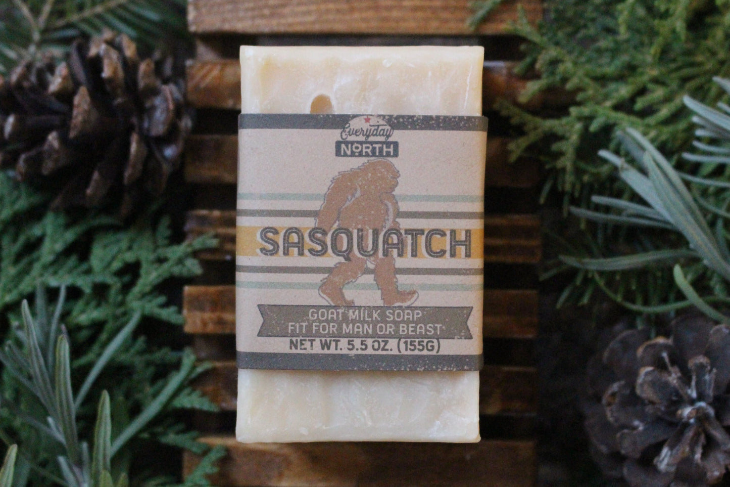 Undyed Soap Bar on Soap Dish. Wrapped in Kraft Label. Everyday North Goat Milk Soap. Sasquatch. Goat Milk Soap Fit For Man or Beast. 5.5 oz. 155 grams. Surrounded by decor. 