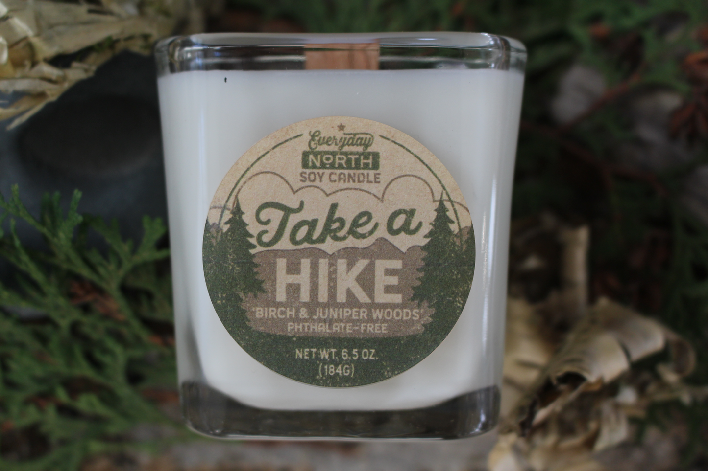 Everyday North Wood Wick Soy Candle. Take a Hike. Birch and Juniper Woods. Phthalate Free. 6.5 oz. 184 grams. Decor Surrounding Undyed Soy Wax Candle in Cube Glass Jar.